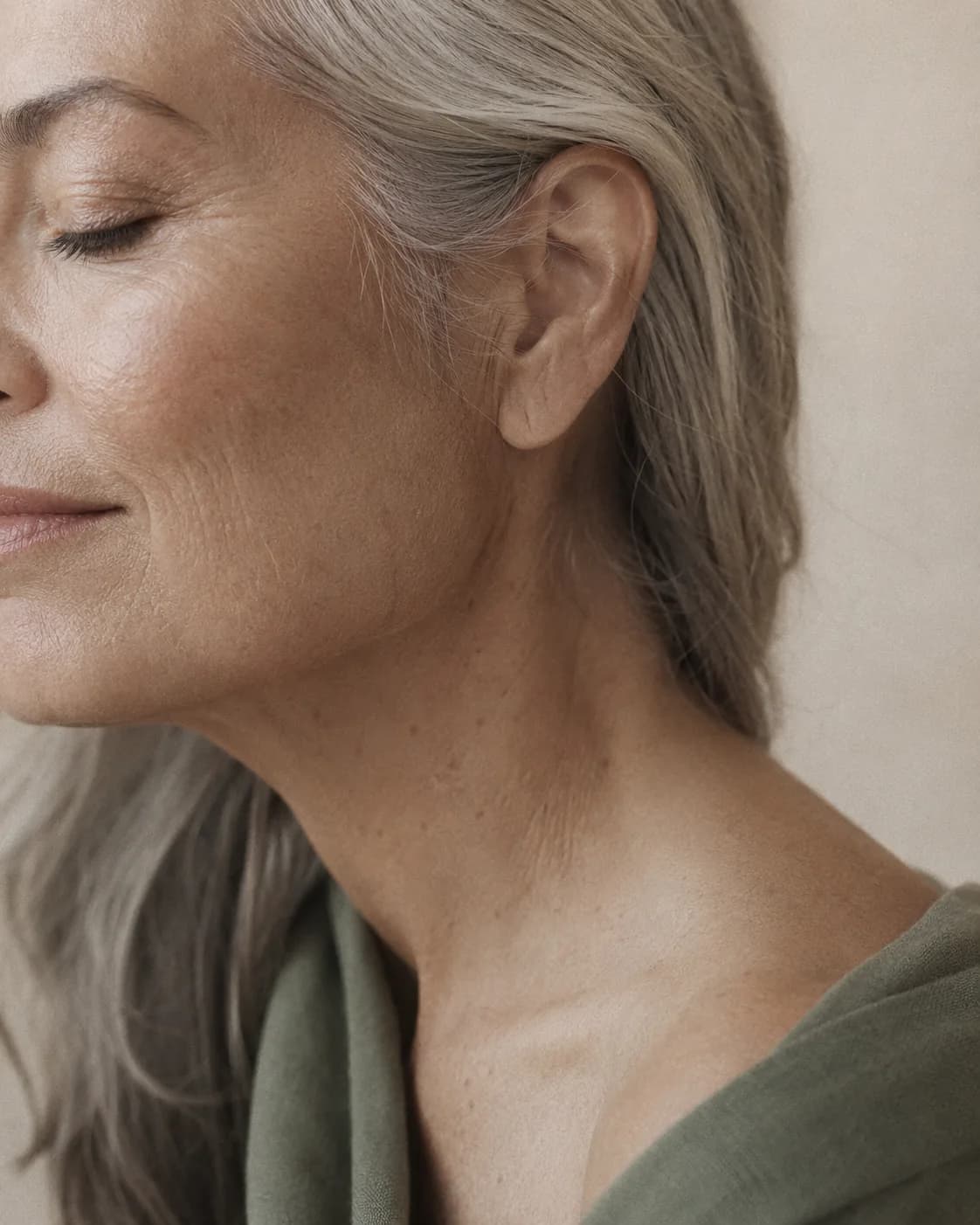 Soft, even editorial skin photography on a warm ground.